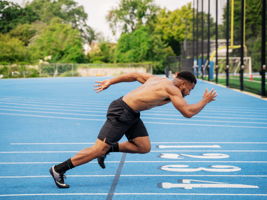 Sprinter during acceleration highlighting lower limb musculature and muscle fiber function in athletic performance.